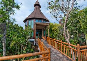 Casa con una pasarela de madera que conduce a una casa en Vidanta Riviera Maya, en Puerto Morelos
