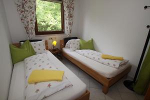 ein kleines Zimmer mit 2 Betten und einem Fenster in der Unterkunft Wessely Appartements am Golfplatz in Innsbruck