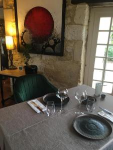 a table with wine glasses on top of it at Logis Hôtel Le Moulin de Chalons in Le Gua