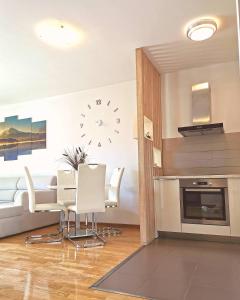 a kitchen with a table and chairs and a clock on the wall at Apartment Stefano in Bar