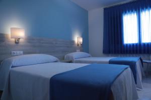 Habitación hospital con 2 camas con iluminación azul en Hotel Las Catedrales en Pumarín
