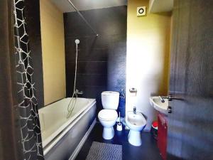 a bathroom with a toilet and a tub and a sink at Apartament Select Mamaia in Mamaia