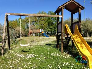 a playground with slides and swings in a field of flowers at Divacamp San Marino in San Marino