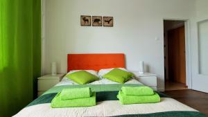 łóżko z dwoma limonkowymi poduszkami w obiekcie Apartament Jeleń w Hajnówce
