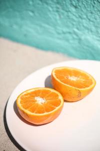 
an orange sitting on top of a white plate at Peneco Albufeira GuestHouse in Albufeira
