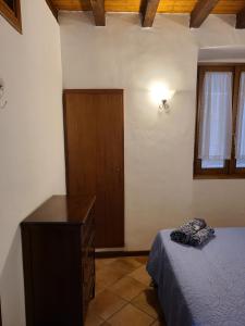 Un dormitorio con una cama y una cómoda y una ventana. en Casa Francesca, en Gargnano