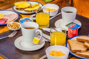 a table topped with cups of coffee and breakfast foods at Hotel Casa Algarrobo in San Pedro de Atacama