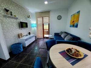 a living room with a blue couch and a table at Zlatibor Hills Royal in Zlatibor