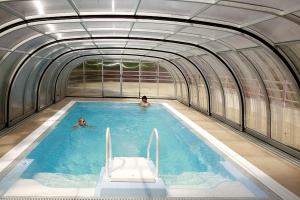 two people swimming in an indoor swimming pool at Hotel Solina Resort & Spa in Solina