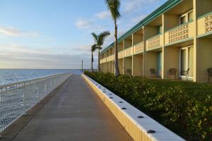 un paseo junto a un edificio junto al océano en Punta Gorda Waterfront Hotel & Suites, en Punta Gorda