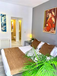 sypialnia z łóżkiem i obrazem na ścianie w obiekcie Apartamentos Puerta Del Sol w Madrycie