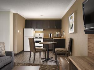 a kitchen and living room with a table and chairs at BEST WESTERN PLUS Carlton Plaza Hotel in Victoria