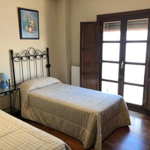 a bedroom with two beds and a sliding glass door at La casa de Tita Elvira 2 in Zafarraya