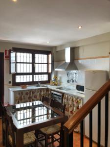 a kitchen with a table with chairs and a refrigerator at La casa de Tita Elvira 2 in Zafarraya