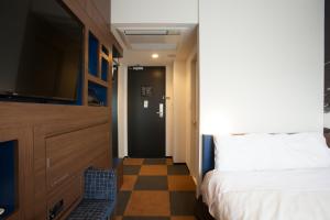 a bedroom with a bed and a flat screen tv at Henn na Hotel Tokyo Haneda in Tokyo