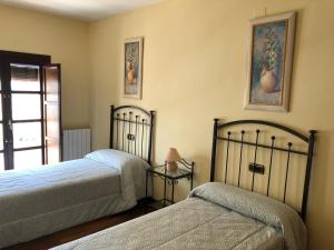 une chambre avec deux lits et une fenêtre dans l'établissement La casa de Tita Elvira 6, à Zafarraya