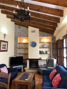 - un salon avec des canapés bleus et une cheminée dans l'établissement La casa de Tita Elvira 6, à Zafarraya
