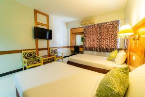 a hotel room with two beds and a tv at The Holidays Hill betong in Betong +25 photos