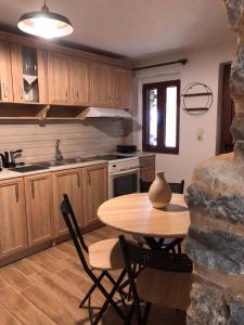 uma cozinha com uma mesa e cadeiras de madeira e uma mesa e uma mesa em Kamares Stone House 1 em Álika
