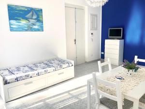 マリーナ・ディ・マンカヴェルサにあるVilla Azzurraのベッドルーム(ベッド1台、テーブル、テレビ付)