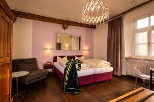 um quarto com uma cama, uma cadeira e um espelho em Hotel Münchner Hof und Blauer Turm em Regensburg