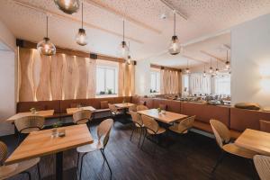 um restaurante com mesas e cadeiras de madeira e um bar em Hotel Villa Bodeblick em Schierke