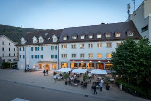 een groot wit gebouw met mensen die ervoor lopen bij Hotel Messmer in Bregenz