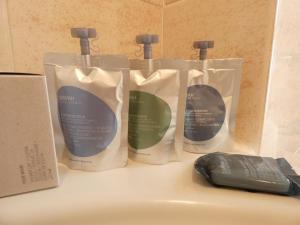 three bottles of hair products on a counter with a mouse at Apartment Nido Stazione in Bergamo +68 photos