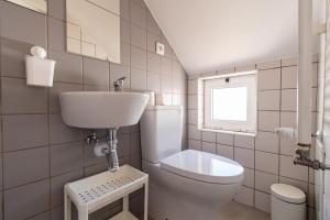 a white bathroom with a toilet and a sink at Casa Carolina in Vila Real de Santo António +20 photos