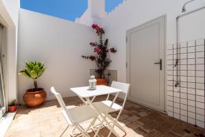 a small white table and chairs in a room at Casa Carolina in Vila Real de Santo António