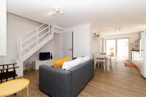 a living room with a gray couch and a staircase at Casa Carolina in Vila Real de Santo António