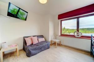 a living room with a couch and a window at Hotel Zlechov in Plumlov