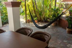 a patio area with a table, chairs, and umbrellas at Villas Carrizalillo in Puerto Escondido