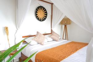 a bedroom with a bed and a clock on the wall at Aryautama Garden Villa in Munduk