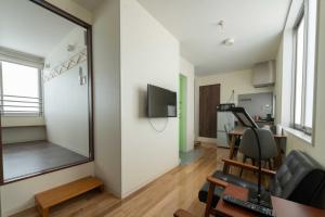 a living room with a mirror and a table and chairs at bmj Hyakunincho in Tokyo