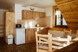 a kitchen with wooden cabinets and a white refrigerator at Apartmány Pod Stráni in Malá Morávka