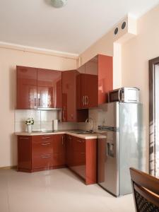 eine Küche mit braunen Schränken und einem Kühlschrank aus Edelstahl in der Unterkunft Apartamenty na Cichej 5 a4 in Kołobrzeg
