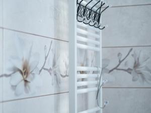 ein weißer Handtuchhalter im Bad mit Vögeln an der Wand in der Unterkunft Apartamenty na Cichej 5 a4 in Kołobrzeg