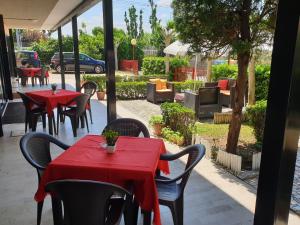 2 mesas y sillas con manteles rojos en un patio en Hotel Paradiso en Rímini