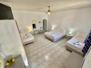 a living room with two white couches and a table at Anna Studios in Katapola