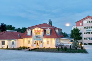 a white house with a red roof and a building at Designhotel Whitman in Ascheberg