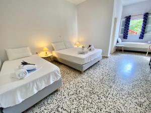 a white room with two beds and a couch at Anna Studios in Katapola