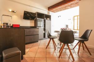 a kitchen with black cabinets and a table and chairs at L'Appart' du 10 - T3 4 downtown Annecy with canal view in Annecy +16 photos