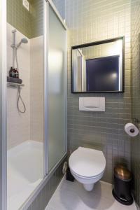 een badkamer met een toilet en een douche en een televisie bij Suite César in Gent