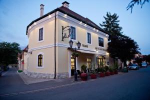 un gran edificio blanco al lado de una calle en Toldi Fogadó en Tokaj