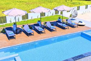 grupa leżaków i parasoli przy basenie w obiekcie Villa Solaris Heated Pool & Jacuzzi w mieście Georgioupolis +31 zdjęć
