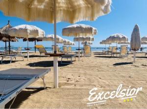 a beach area with umbrellas and chairs at Hotel Excelsior in Montesilvano