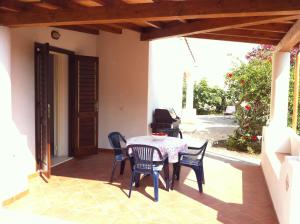a patio with a table and chairs on a porch at Villa by the Vulcano - 70mq plus large garden and patio in Vulcano