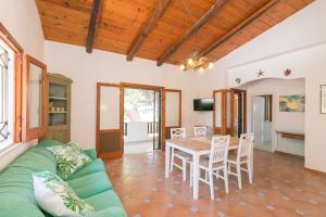 a living room with a green couch and a table at Villa Plemmyria in Syracuse