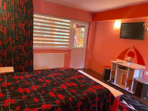 a bedroom with a bed with red walls and a window at Casa Nicoli in Băile Olăneşti